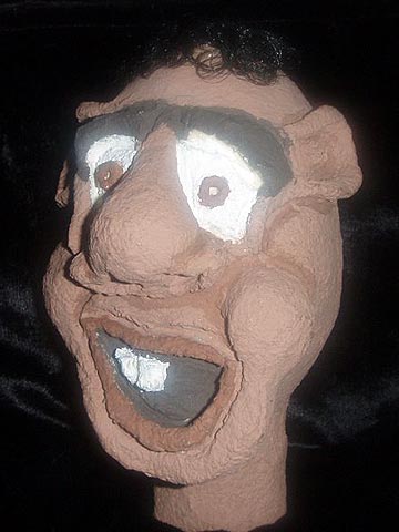 Cabeça de um boneco feio como um Jéca, feito em papél machê para um espetáculo de teatro infantil.